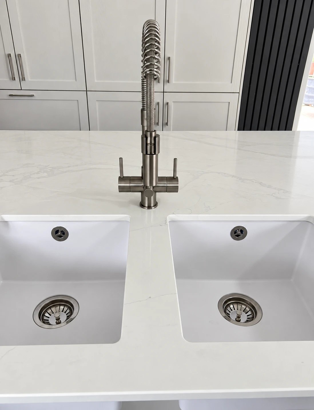 Brushed-steel three-way filtered-water kitchen tap installed by Precision in Aylsham, on a quartz island with twin undermount sinks