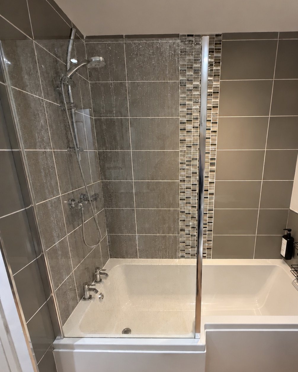 Shower screen and tiles covered in hard-water limescale marks before a softener was fitted