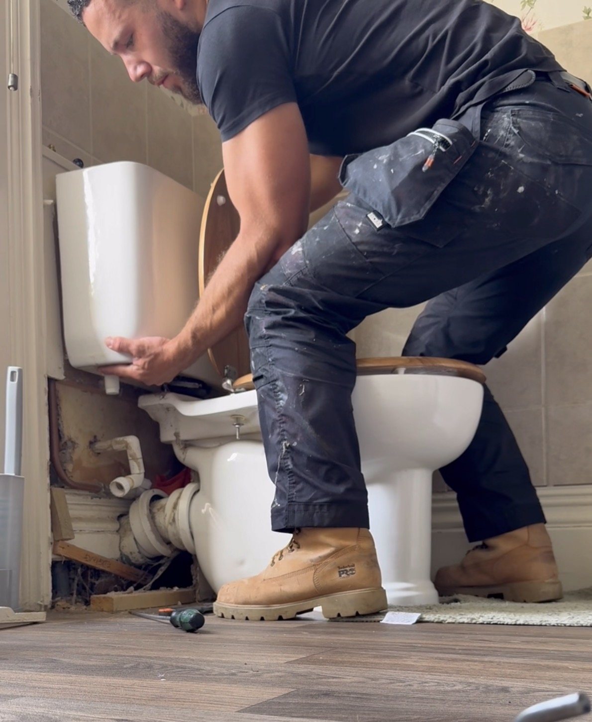 Precision plumber refitting a toilet cistern