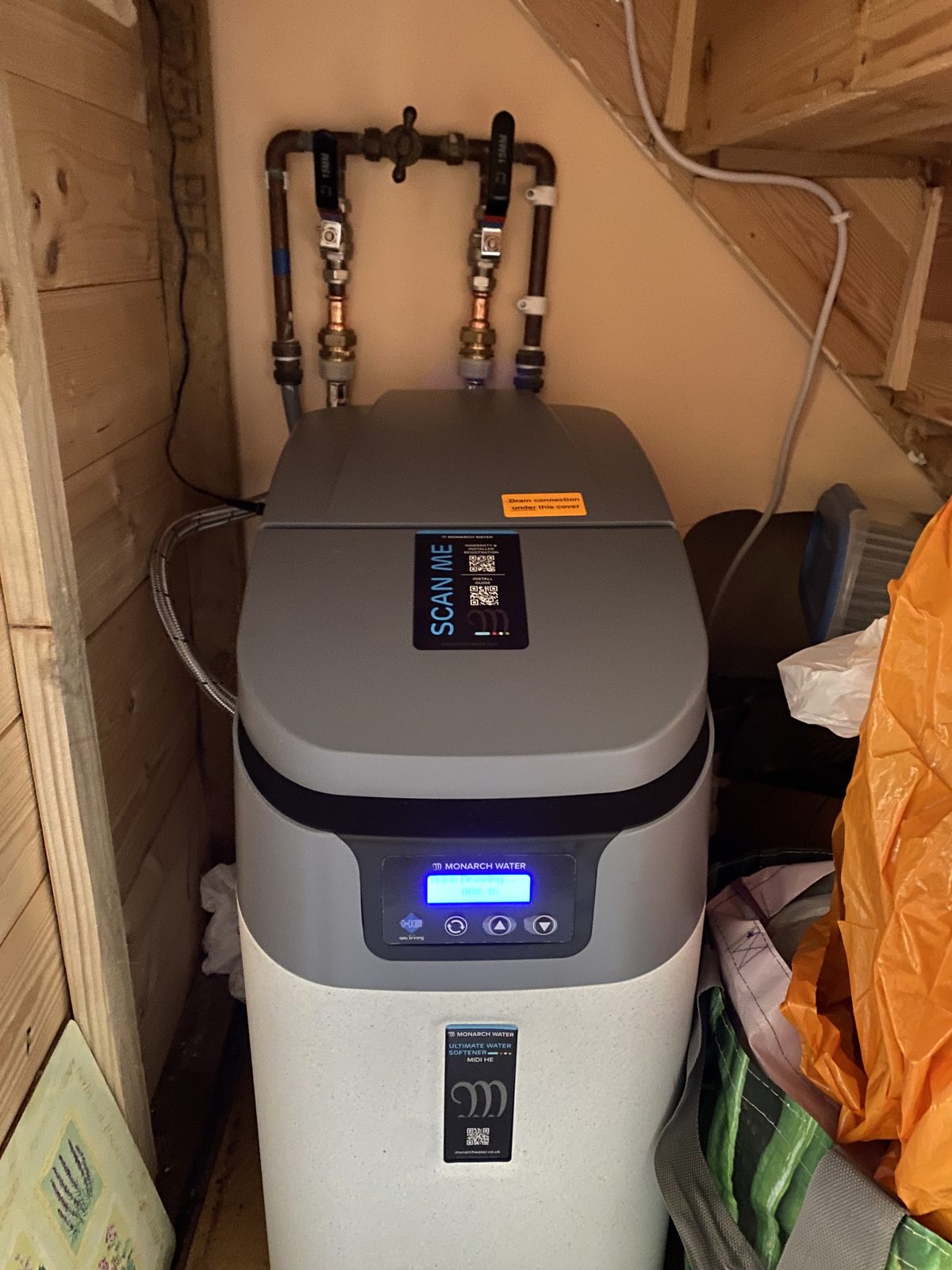 Water softener installed by Precision in an under-stairs cupboard, with bypass and isolation valves